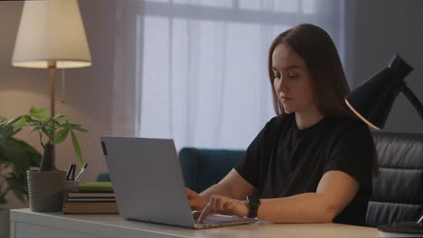 Erschöpfte-Frau-Mit-Laptop-Im-Home-Office-Am-Abend,-Die-Auf-Der-Tastatur-Des-Laptops-Tippt-Und-Kopfschmerzen-Verspürt,-Wenn-Sie-Die-Abdeckung-Schließt-Und-Sich-Entspannt